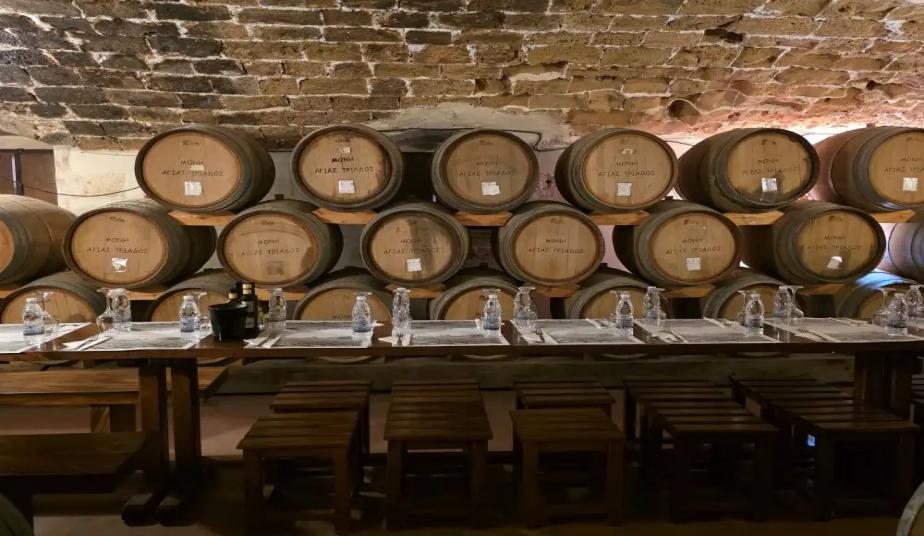 Wine barrels and the tasting table in the cellar of Agia Triada Monastery