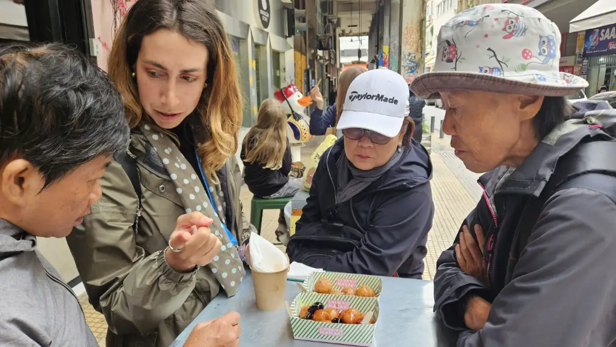 Private tour guide sharing local Athens street food with guests during a food tour