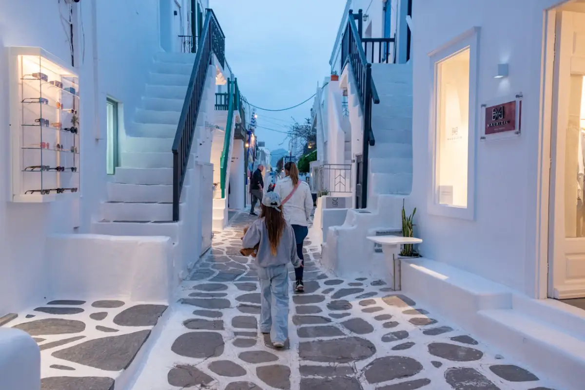 Matogiannia lane in Mykonos Town at night, whitewashed buildings lit by evening light