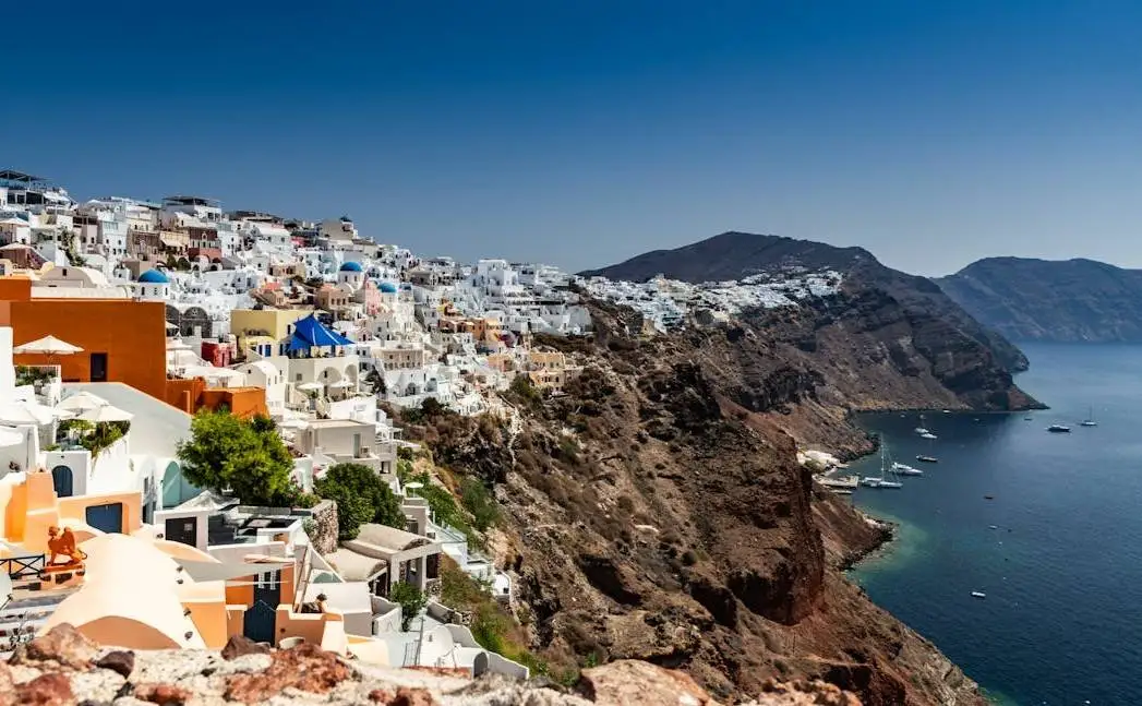 Oia village Santorini caldera view, whitewashed houses on volcanic cliffs above the Aegean Sea
